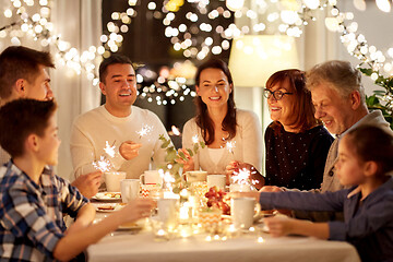 Image showing family with sparklers having tea party at home