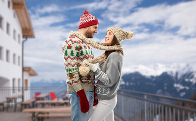 Image showing couple in ugly christmas sweaters over ski resort