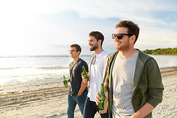 Image showing young men with non alcoholic beer walking on beach