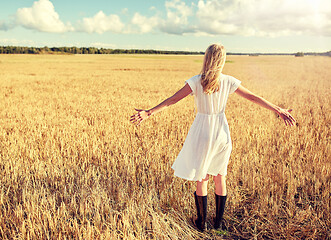 Image showing happy young woman in white dress on cereal field