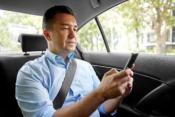 Image showing passenger or businessman using smartphone in car