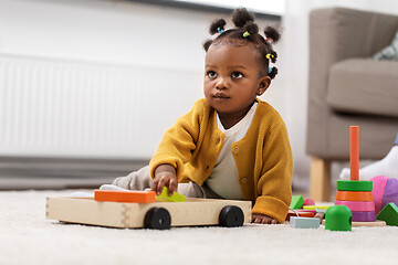 Image showing african baby girl playing with toy blocks at home