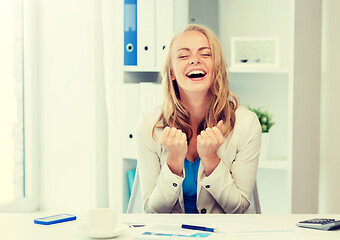 Image showing happy businesswoman celebrating success at office