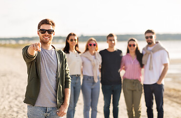 Image showing happy man with friends on beach in summer