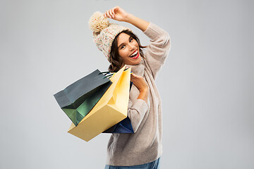 Image showing young woman in winter hat with shopping bags