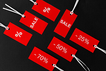 Image showing red tags with discount signs on black background