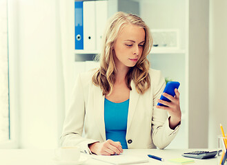 Image showing businesswoman texting on smartphone at office