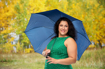 Image showing happy woman with blue umbrella over autumn park