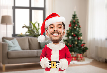 Image showing smiling man in santa costume over christmas tree