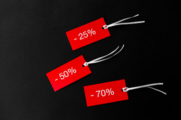 Image showing red tags with discount signs on black background