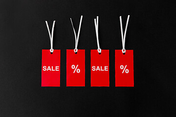 Image showing red tags with discount signs on black background