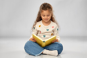 Image showing beautiful smiling girl reading book on floor