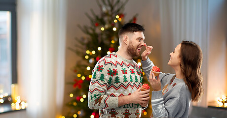 Image showing couple with cupcakes in ugly christmas sweaters