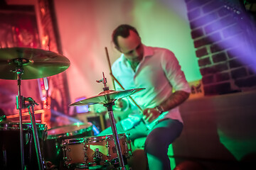 Image showing Drummer playing on drum set on stage.