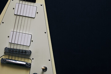 Image showing White V shape electric guitar on dark grunge background.