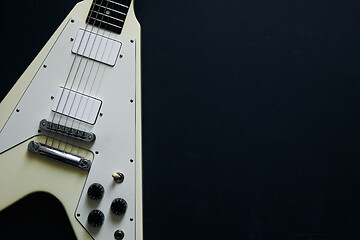 Image showing White V shape electric guitar on dark grunge background.