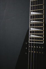 Image showing Black V shape electric guitar on dark grunge background.