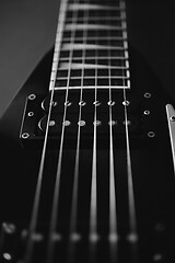 Image showing Black V shape electric guitar on dark grunge background.