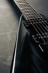 Image showing Black V shape electric guitar on dark grunge background.