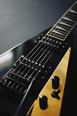 Image showing Black V shape electric guitar on dark grunge background.