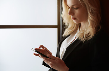 Image showing Young adult woman using smartphone at the office