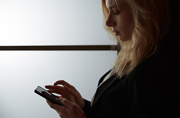 Image showing Young adult woman using smartphone at the office