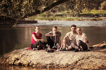 Image showing friends smoking hookah on the river bank