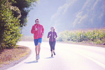 Image showing young couple jogging along a country road