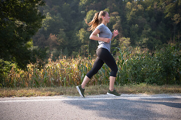 Image showing woman jogging along a country road