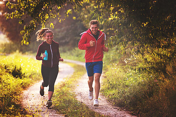 Image showing young couple jogging along a country road