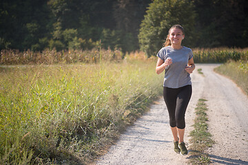 Image showing woman jogging along a country road