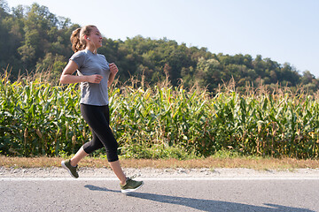 Image showing woman jogging along a country road