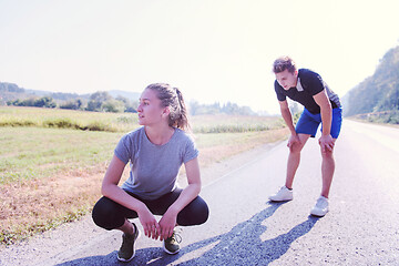 Image showing young couple warming up and stretching on a country road