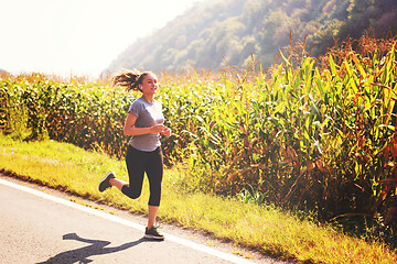 Image showing woman jogging along a country road