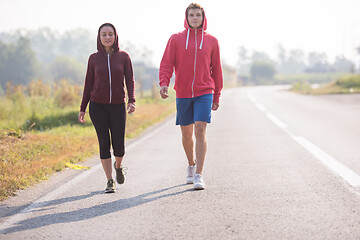 Image showing young couple jogging along a country road