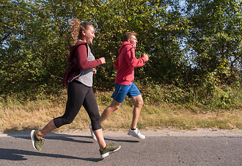 Image showing young couple jogging along a country road