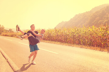 Image showing happy couple jogging along a country road