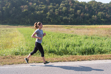 Image showing woman jogging along a country road