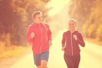 Image showing young couple jogging along a country road