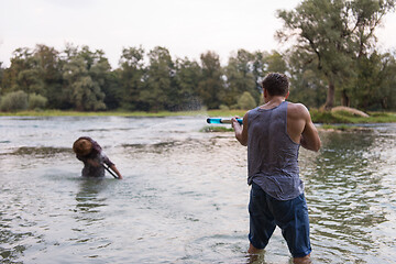 Image showing young men having fun with water guns