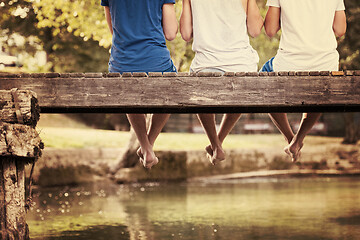 Image showing people sitting at wooden bridge