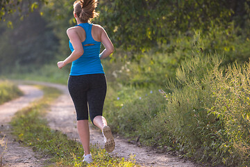 Image showing woman jogging along a country road