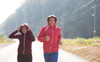 Image showing young couple jogging along a country road