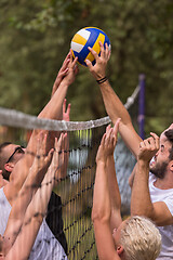 Image showing group of young friends playing Beach volleyball