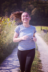 Image showing woman jogging along a country road