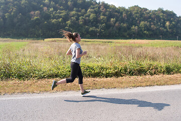 Image showing woman jogging along a country road