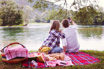 Image showing Couple taking a selfie by mobile phone while enjoying picnic tim