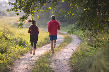 Image showing young couple jogging along a country road