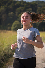 Image showing woman jogging along a country road