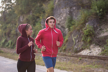 Image showing young couple jogging along a country road